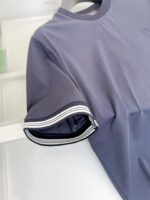 Maglietta navy blu con polsini a righe e taglio classico, versatile e di qualità.