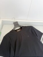 Maglietta nera semplice con logo minimalista, ideale per look casual e versatile.