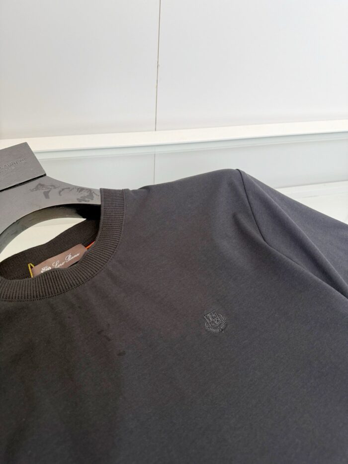 Maglietta nera semplice in cotone con logo discreto, stile minimalista e versatile.