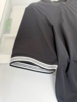 Maglietta nera con dettagli a righe bianche sul polsino, stile sportivo e di qualità.