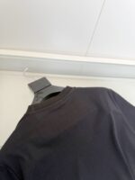Maglia nera classica su appendiabiti in ambiente moderno, stile minimalista e raffinato.