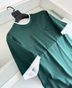 T-shirt verde con dettagli bianchi, logo discreto, stile sportivo e casual in cotone.