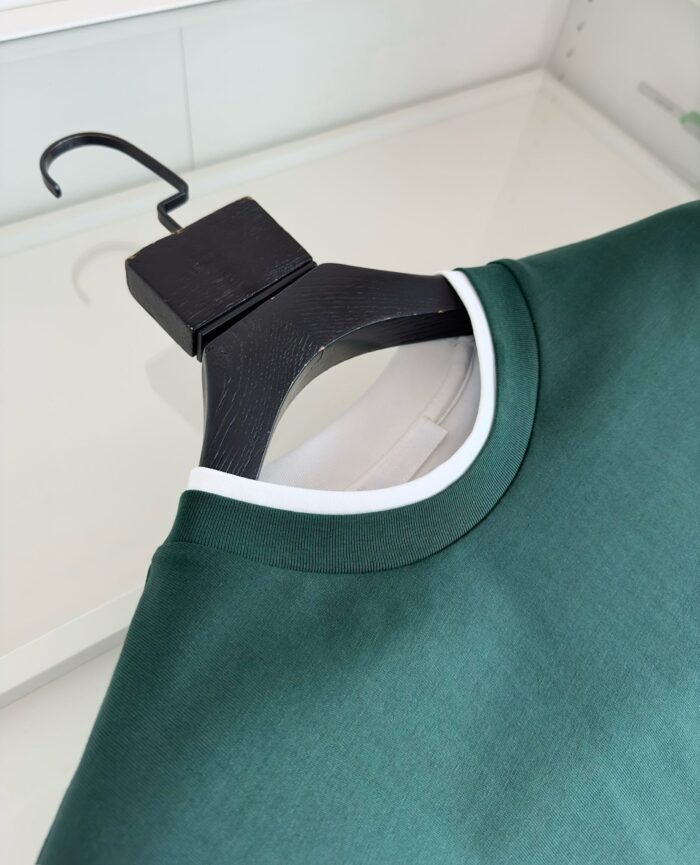 Maglietta verde con bordo bianco, stile casual e raffinato, perfetta per un look quotidiano.
