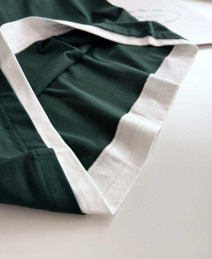 Tessuto verde sportivo con bordo bianco, ideale abbigliamento casual e attivo elegante.