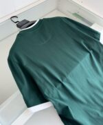 Maglietta sportiva verde con dettagli bianchi, ideale per look casual e comodi.