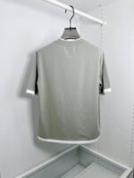 Camicia sportiva grigia con dettagliContrastati, maniche raglan e design minimalista elegante.