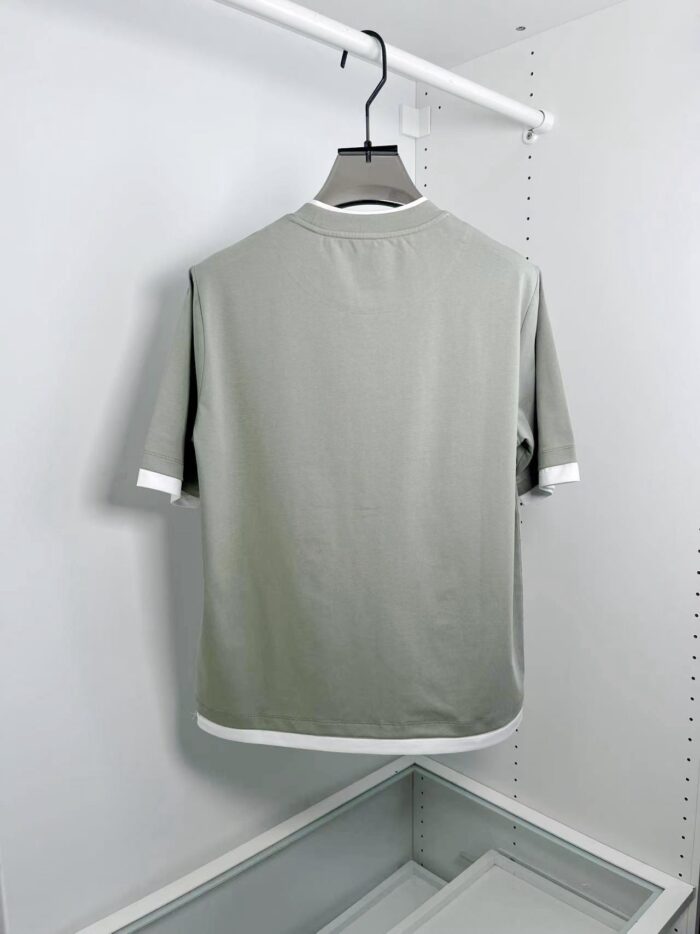 Camicia sportiva grigia con dettagliContrastati, maniche raglan e design minimalista elegante.