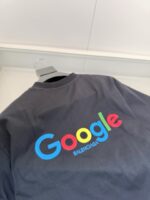 Maglietta Balenciaga e Google con logo colorato su sfondo nero, moda e tecnologia uniti.