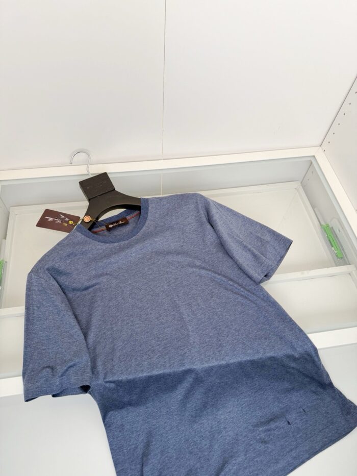 Maglietta blu heathered semplice in esposizione moderna su vetrina trasparente.