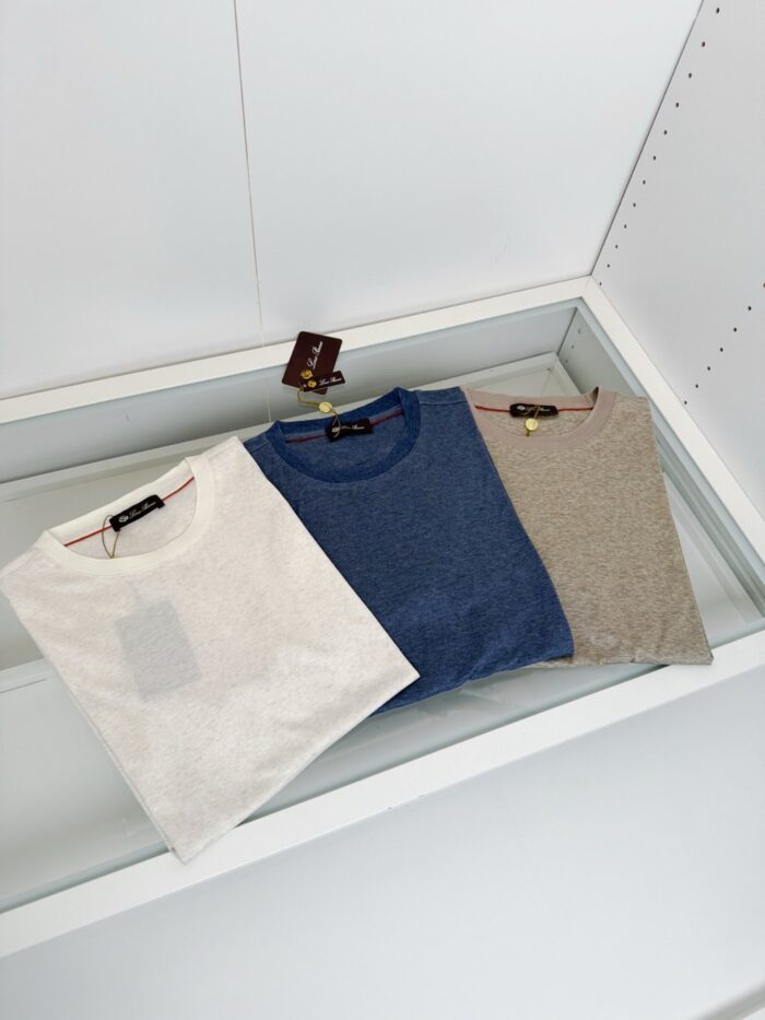 Magliette casual in bianco, blu e grigio su vetrina moderna per look everyday.