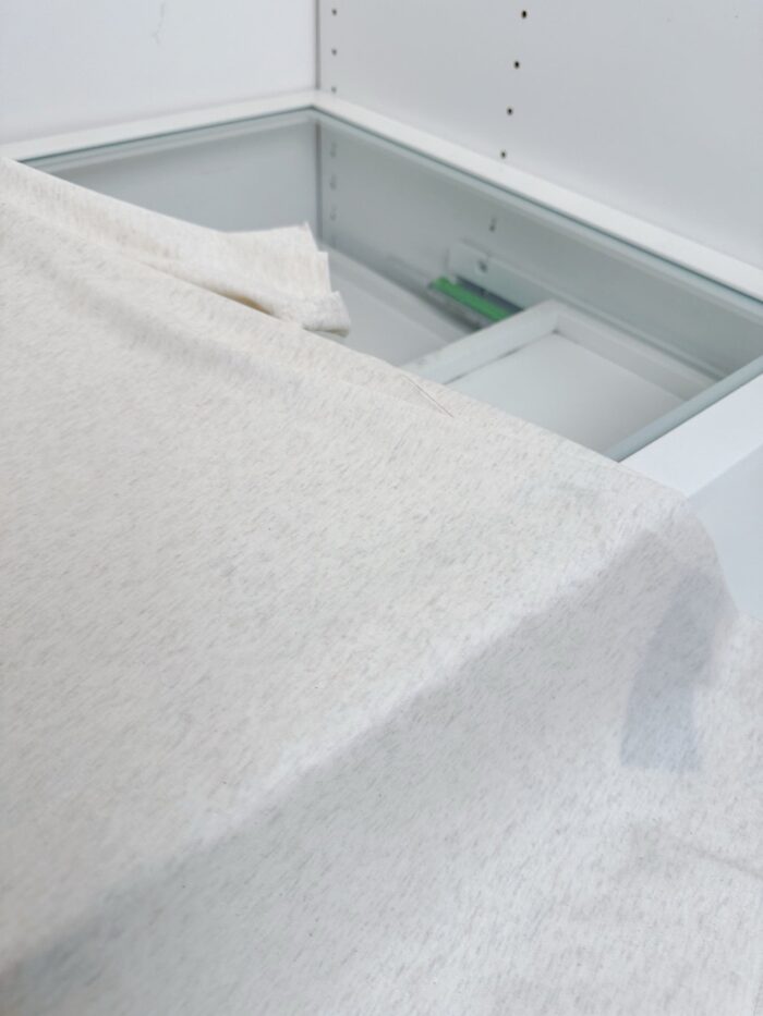 Tessuto morbido su mobile in ambiente minimalista e luminoso con box in vetro trasparente.