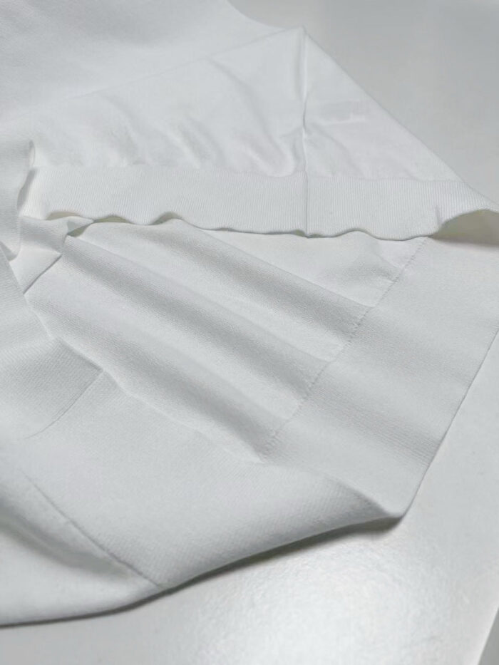 Tessuto bianco morbido, elegante e di alta qualità, perfetto per ogni occasione.