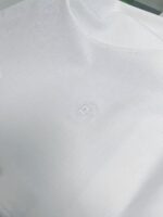 Maglietta bianca minimalista con logo discreto, tessuto morbido e design elegante.