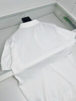 Camicia polo bianca elegante esposta, moderna e di alta qualità, ideale per look casual e sofisticati.