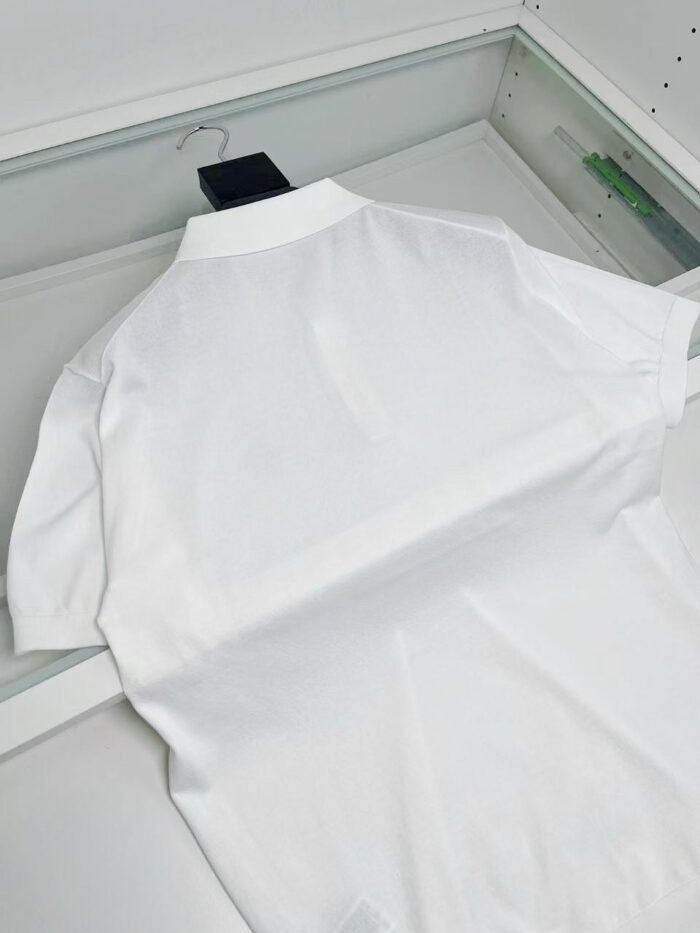 Camicia polo bianca elegante esposta, moderna e di alta qualità, ideale per look casual e sofisticati.