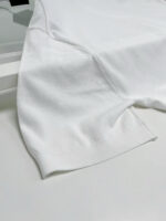 Maglietta bianca minimalista con cuciture eleganti, ideale per look casual e sofisticati.