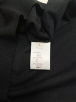 Etichetta di abbigliamento L con materiali sintetici e istruzioni di cura.