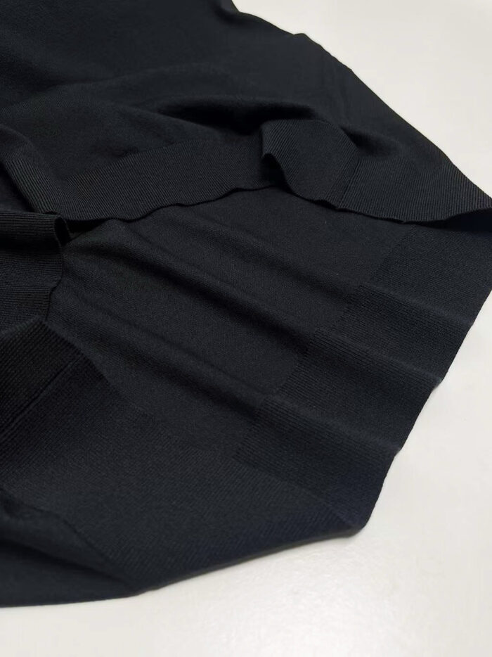 Tessuto nero elegante con pieghe morbide, ideale per abiti sofisticati e di stile.