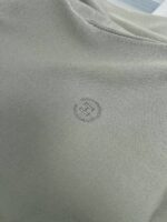 Maglietta minimalista in tessuto morbido con logo discreto, collo rotondo e stile versatile.