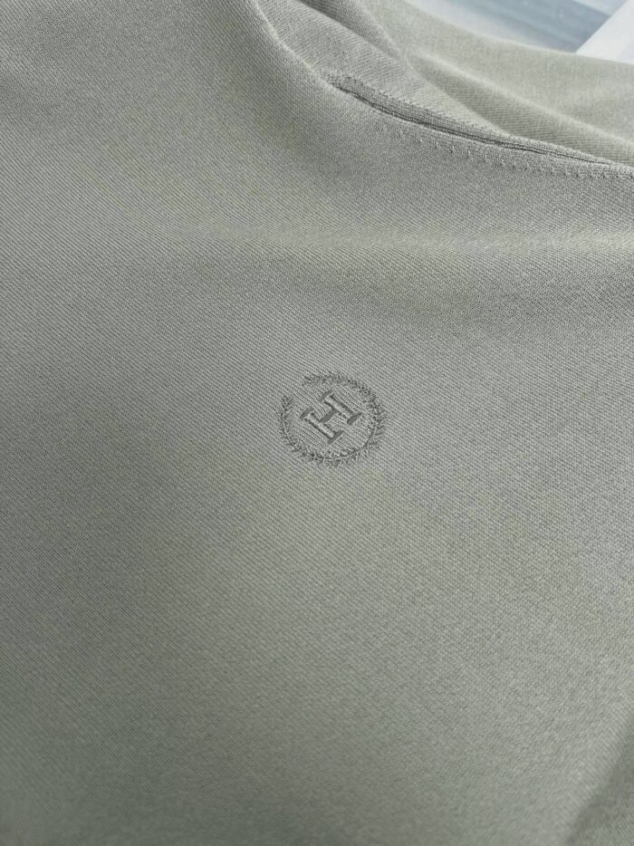 Maglietta minimalista in tessuto morbido con logo discreto, collo rotondo e stile versatile.