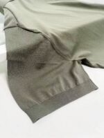 Maglietta verde oliva con maniche morbide e dettagli elastici, stile casual e moderno.