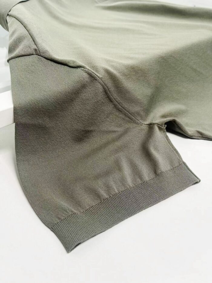 Maglietta verde oliva con maniche morbide e dettagli elastici, stile casual e moderno.