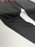 Leggings sportivi neri con logo embossato MON1952, comodi, elasticizzati e dallo stile minimalista.