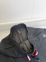 Giacca sportiva moderna con colletto elasticizzato e dettagli rossi, bianchi e blu.