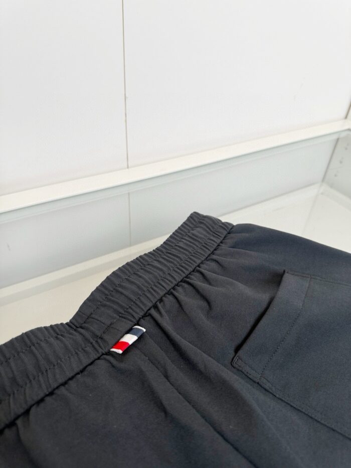 Pantaloni casual in cotone con elastico, tasca laterale e logo tricolore, stile comodo e versatile.