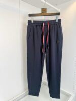 Pantaloni sport navy con elastico, cordini rossi e bianchi, stile casual e comfort elevato.