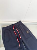 Pantaloni jogging navy con logo, elastico regolabile e cordino colorato, stile casual e confortevole.