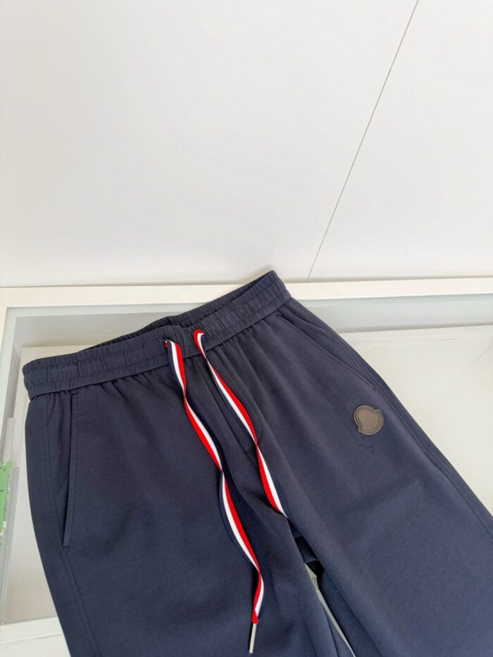Pantaloni jogging navy con logo, elastico regolabile e cordino colorato, stile casual e confortevole.