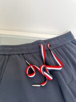 Pantaloni jogger grigi con stringhe colorate e aglet metallico, comfort e stile casual.