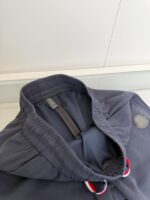 Colletto con cappuccio navy, dettagli sportivi e coulisse rosse e bianche.