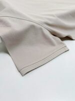 Manica in tessuto beige morbido, dettagli di cucitura precisa, stile elegante e versatile.