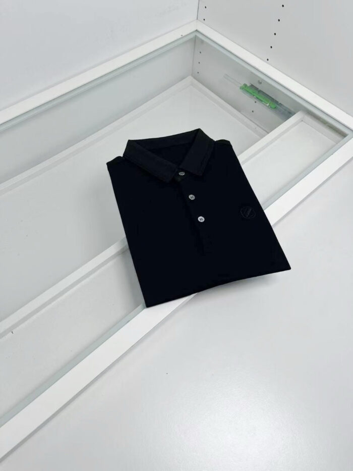 Camicia polo nera in esposizione minimalista, elegante e di qualità in vetrina moderna.