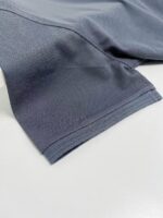 Manica di abbigliamento sportivo in tessuto tecnico grigio, leggero e traspirante.
