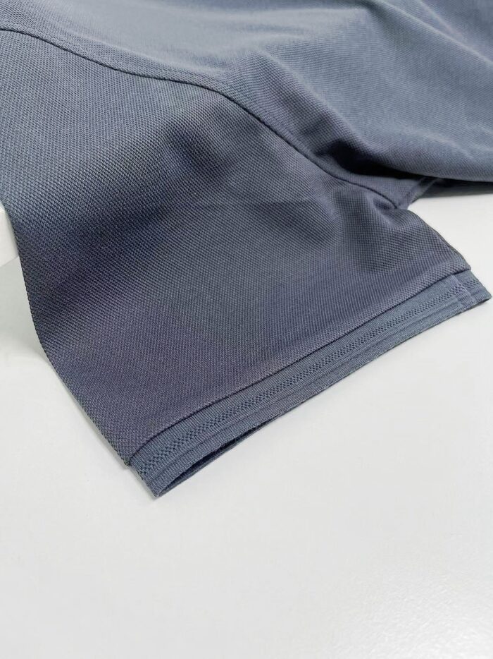 Manica di abbigliamento sportivo in tessuto tecnico grigio, leggero e traspirante.