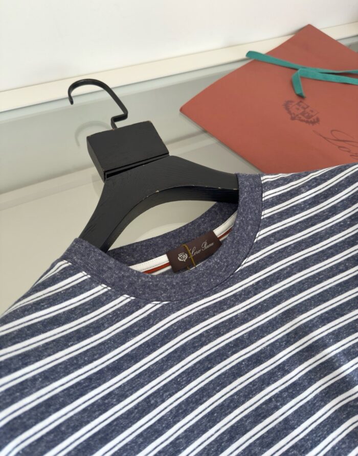 Camicia a righe navy e bianco, stile casual, con dettagli colorati su sfondo neutro.