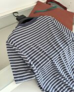Camicia a righe blu e bianco con borse eleganti, stile casual e sofisticato.