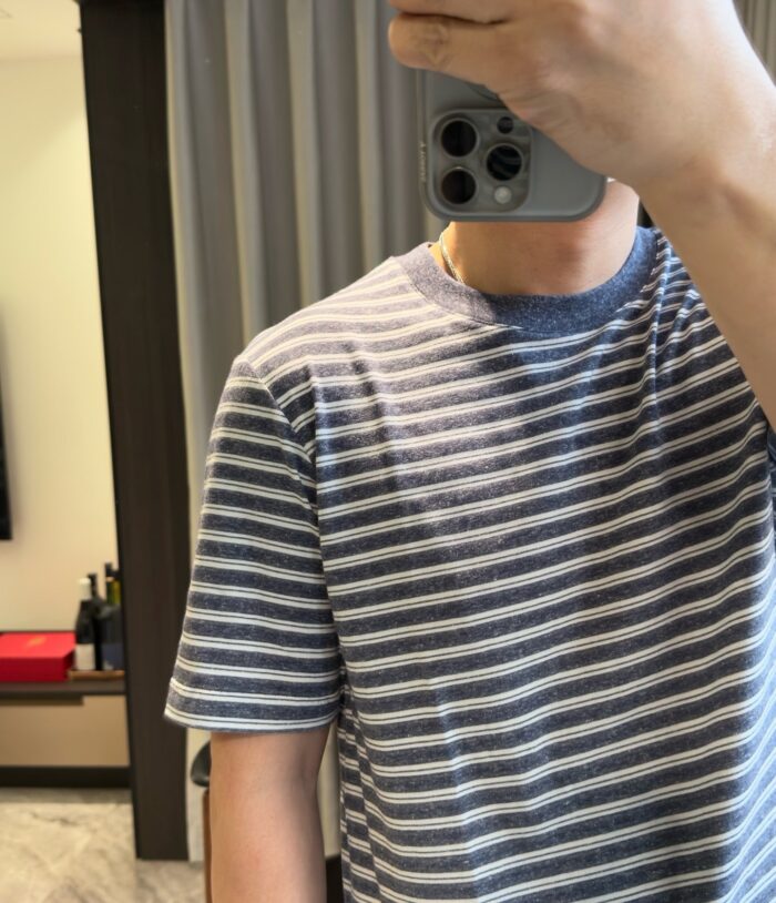 Selfie con maglietta a righe grigia in uno stile casual e ambiente domestico moderno.