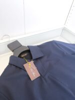Maglietta polo navy blu elegante con tag, ideale per outfit casual o semi-formali.