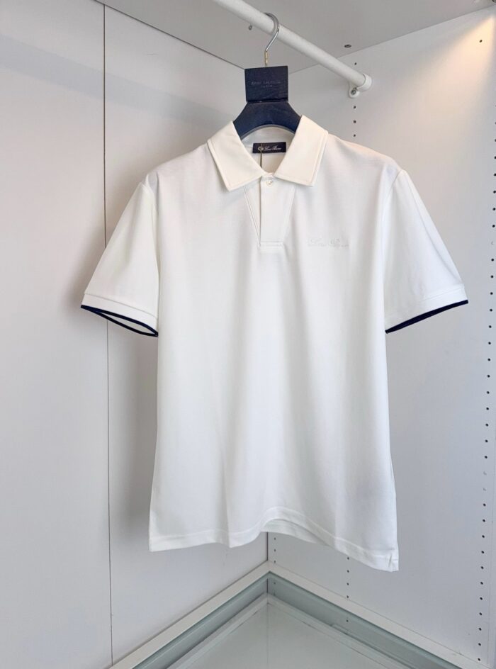 Maglietta polo bianca elegante con collo classico e dettagli a contrasto sulle maniche.