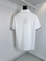 Maglietta polo bianca con dettagli neri, stile minimalista e versatile.