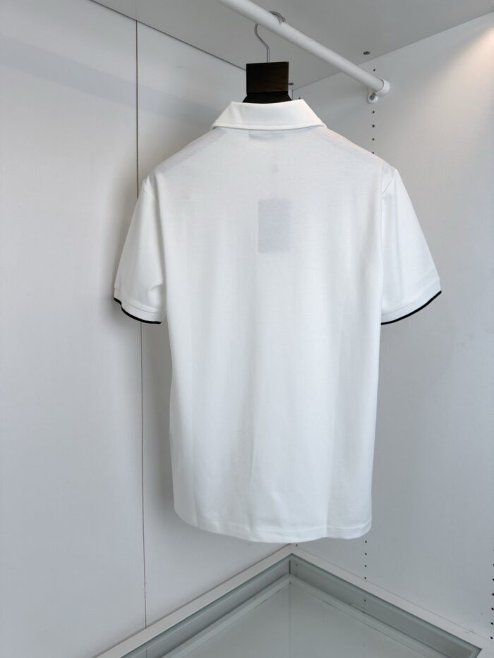 Maglietta polo bianca con dettagli neri, stile minimalista e versatile.