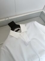 Camicia polo bianca elegante in scatola trasparente, stile minimalista e vestibilità moderna.
