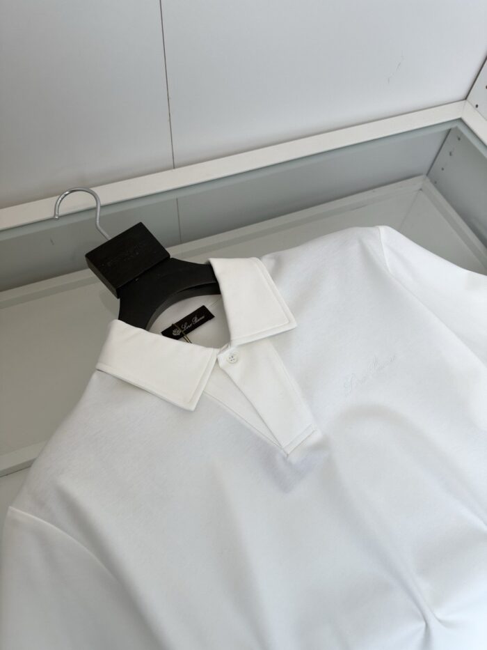 Camicia polo bianca elegante in scatola trasparente, stile minimalista e vestibilità moderna.
