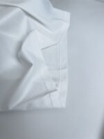 Tessuto bianco di alta qualità con cuciture precise e superficie liscia ed elegante.