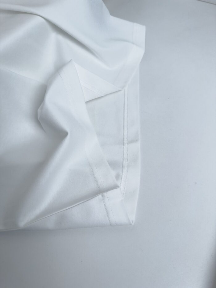 Tessuto bianco di alta qualità con cuciture precise e superficie liscia ed elegante.