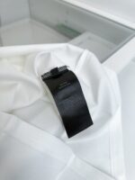 Tessuto bianco con etichetta nera minimalista, stile elegante e di alta qualità.